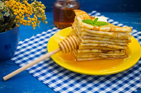 Panquecas com mel, manteiga e um raminho de erva-cidreira. Fundo azul de madeira. Close-up . — Fotografia de Stock
