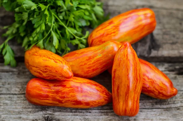 Gestreifte Tomatenpaprika-Sorte auf einem hölzernen Hintergrund. Ansicht von oben. Nahaufnahme — Stockfoto