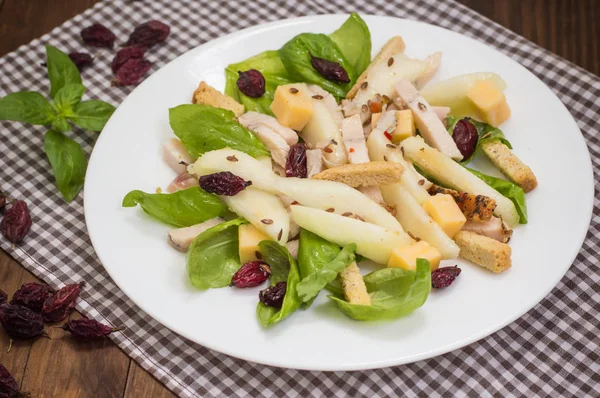 Hühnersalat, Birnen, getrocknete Stachelbeeren und Johannisbeeren, Käse auf Basilikumblättern. Holzuntergrund. Ansicht von oben. Nahaufnahme — Stockfoto