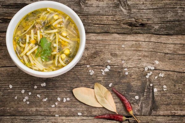 Sopa de fideos de pollo y maíz en la mesa de madera vieja. Vista superior. Primer plano — Foto de Stock