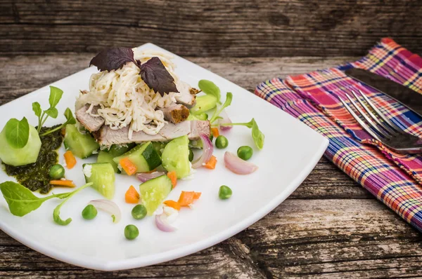 Salat mit gehacktem Backfleisch, geschmolzenem Käse, Gurken, Karotten und Erbsenpüree. Holzuntergrund. Nahaufnahme — Stockfoto
