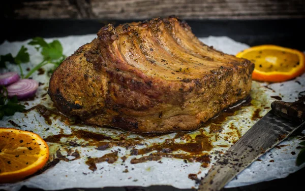 Bagt svinekød ribben med sauce og basilikum på et sort bord. Øverste udsigt. Nærbillede. Selektivt fokus - Stock-foto