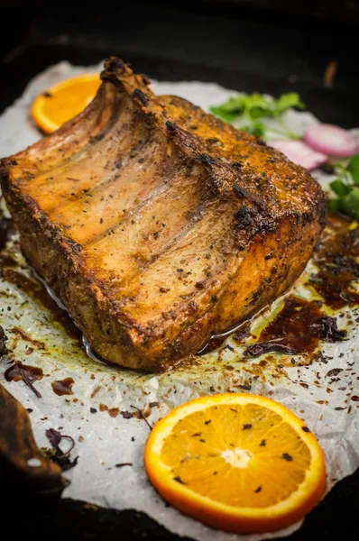 Baked pork ribs with sauce and basil on a black table. Top view. Close-up. Selective focus — Stock Photo, Image