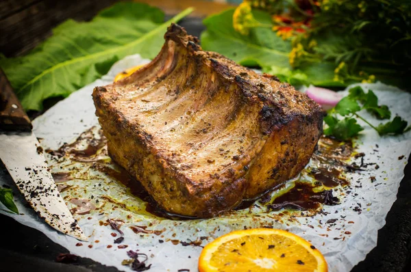 Bagt svinekød ribben med sauce og basilikum på et sort bord. Øverste udsigt. Nærbillede. Selektivt fokus - Stock-foto