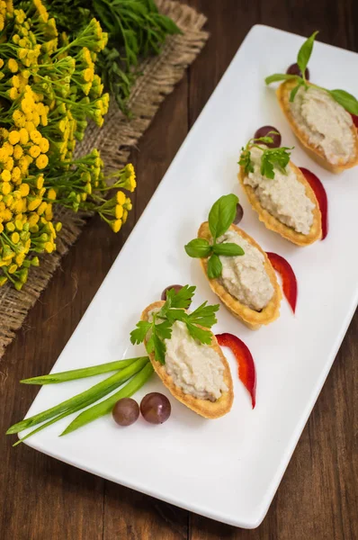 Forshmak, Jewish dish of chopped herring, baked with potatoes, sour cream, onions and peppers, referring to the starters. Filed in the tartlet on a rectangular plate. Wooden background. Close-up. — Stock Image Forshmak, Jewish dish of chopped herring, baked with potatoes, sour cream, onions and peppers, referring to the starters. Filed in the tartlet on a rectangular plate. Wooden background. Close-up. Stock Picture