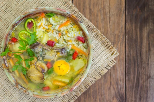 Rice soup with chicken navels and egg yolk. Wooden rustic background. Top view. Close-up — Stock Image Rice soup with chicken navels and egg yolk. Wooden rustic background. Top view. Close-up Stock Photo