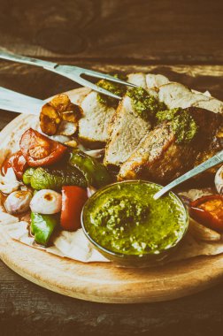 Etli sebze, ızgara ve İtalyan Salsa Verde sos. Ahşap rustik masa. Yakın çekim