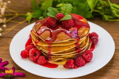 Ahududu reçeli ve taze çilek ile krep. Ahşap arka plan. Yakın çekim