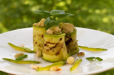 Eritilmiş peynir, fıstık ve fesleğen ile ızgara kabak. Restoran kaynağı. Yeşil arka planı. Yakın çekim
