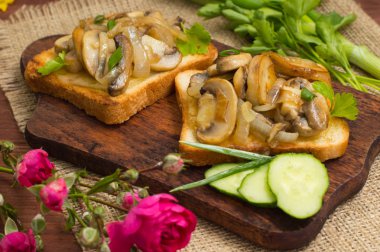 Kızarmış yağlı mantar ve arka plan rengi üzerinde sebze ile tost. Yakın çekim