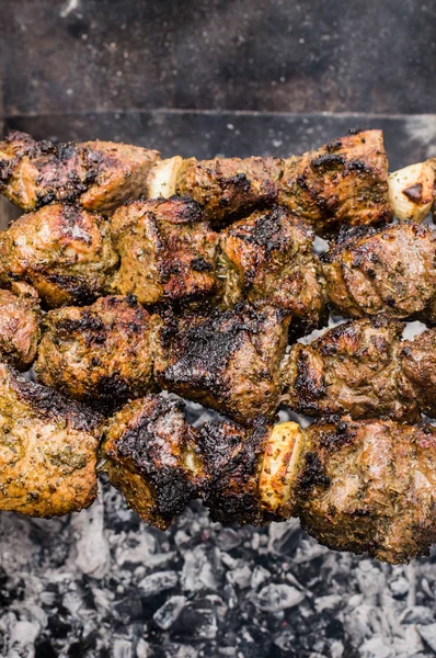 Skewers of lamb cooked on the grill. Wooden background. Top view. Close-up — Stock Photo, Image