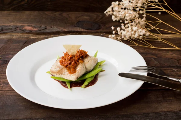 Kokt fisk med kokt sparris, vegetabiliska ragu, tomatsås och potatischips. Trä bakgrund. Ovanifrån. Närbild — Stockfoto