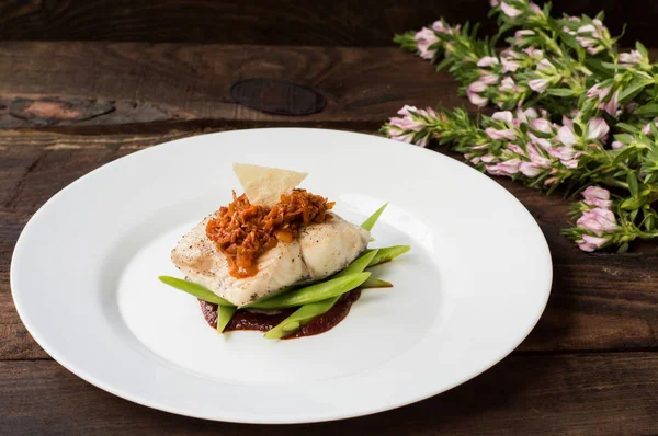 Kokt fisk med kokt sparris, vegetabiliska ragu, tomatsås och potatischips. Trä bakgrund. Ovanifrån. Närbild — Stockfoto