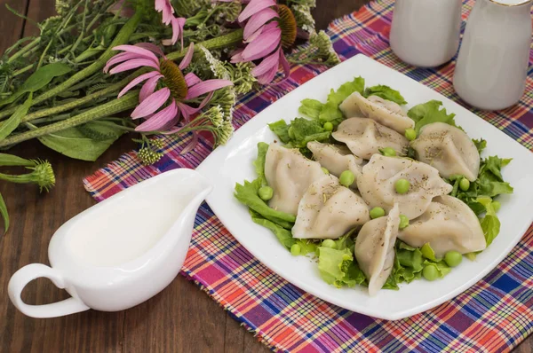 Gnocchi con pollo tritato su un piatto erbe fresche e piselli. Sfondo in legno. Primo piano — Foto Stock