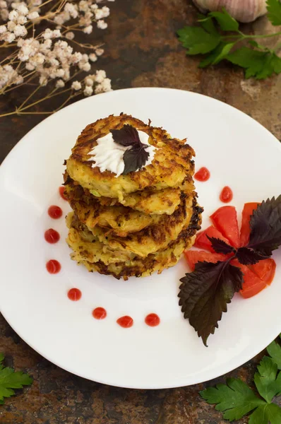 Courgette pannenkoeken met zure room, tomaten en kruiden. Oude achtergrond. Close-up — Stockfoto