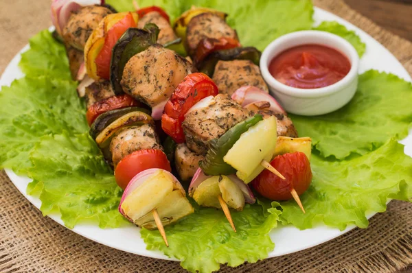 Skewers of chicken and vegetables on wooden . Rural background. Close-up — Stock Photo, Image