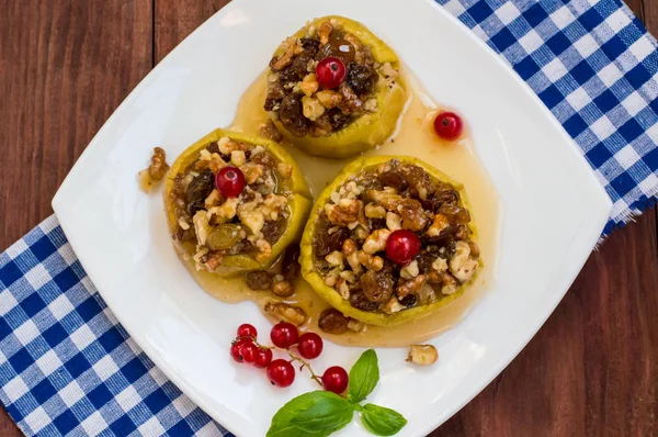 Baked apples with raisins, walnuts and honey for dessert. Wooden rustic background. Close-up. Top view — Stock Photo, Image