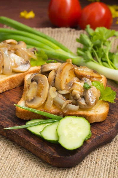 Toast with fried mushrooms and vegetables on the background color. Close-up