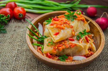 Bir kase domates soslu lahana rulo. ahşap arka plan.