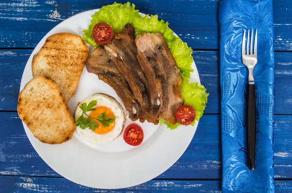 Englisches Frühstück - Spiegelei, Tomaten, Speck und Toast. Ansicht von oben — Stockfoto