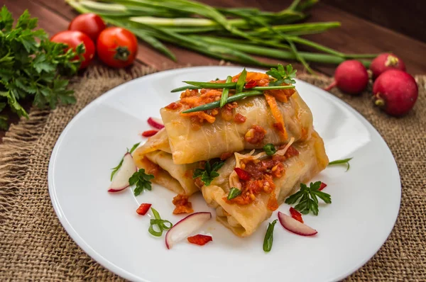 Rotoli di cavolo in salsa di pomodoro. targa bianca. fondo di legno . — Foto Stock