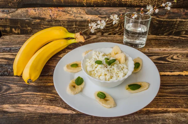 Сир з бананом на сніданок. Дерев'яний фон — стокове фото