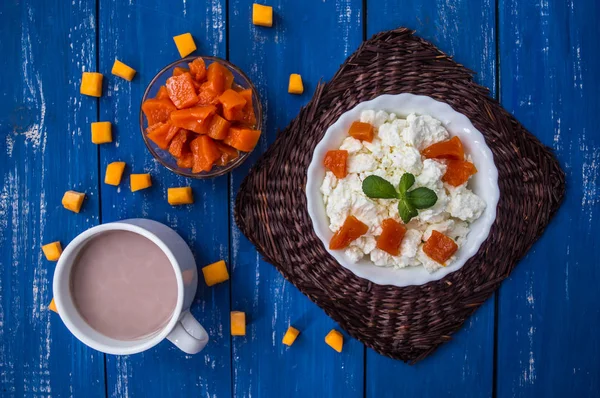 Frukost från keso med pumpa sylt och kakao på en blå trä bakgrund. Ovanifrån — Stockfoto