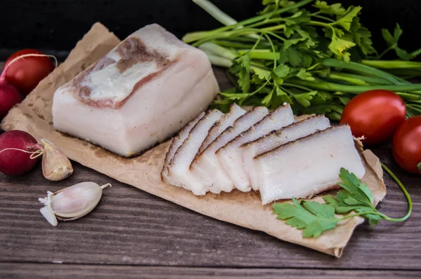 Manteca de cerdo ahumada con pan y verduras al fondo. Rústico de madera — Foto de Stock