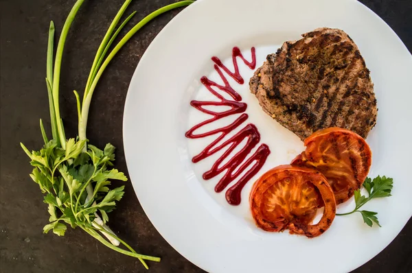 Steak vom Grill mit Gemüse und Beerensauce auf einem weißen Teller. Holzuntergrund. Ansicht von oben — Stockfoto