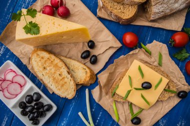 Peynir zeytin, turp ve otlar ile dilimlenmiş. Ahşap bir arka plan üzerinde. Üstten Görünüm. Yakın çekim