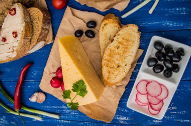 Peynir zeytin, turp ve otlar ile dilimlenmiş. Ahşap bir arka plan üzerinde. Üstten Görünüm. Yakın çekim
