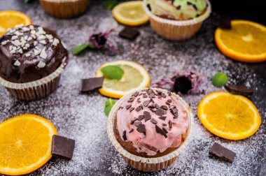 Meyve ve karanlık bir arka plan üzerine pudra şekeri ile cupcakes. Üstten Görünüm. Yakın çekim