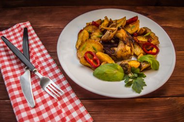 Bıldırcın pişmiş patates ve elma ile. Kahverengi ahşap zemin üzerinde. Yakın çekim