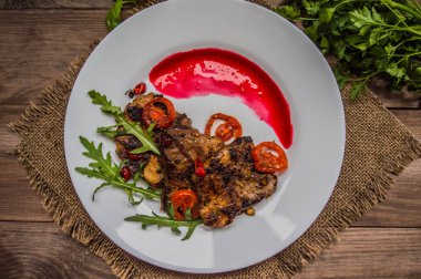 Berry sos ve roka Restoran ızgara kavrulmuş et yemeği. Ahşap rustik arka plan. Üstten Görünüm. Yakın çekim