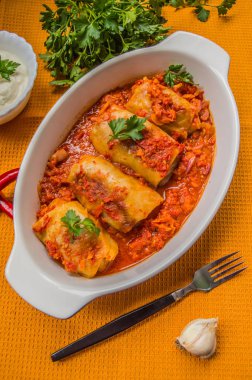 Akşam yemeği domates soslu lahana rulo ile dekore edilmiş maydanoz. Ahşap rustik arka plan mavi. Üstten Görünüm. Yakın çekim