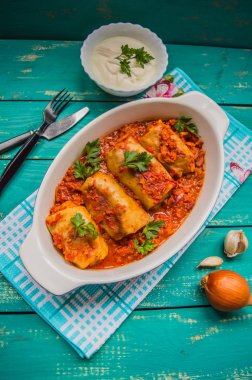 Akşam yemeği domates soslu lahana rulo ile dekore edilmiş maydanoz. Ahşap rustik arka plan mavi. Üstten Görünüm. Yakın çekim