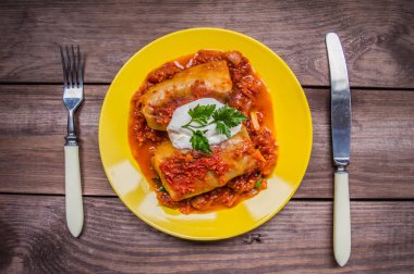 Akşam yemeği domates soslu lahana rulo ile dekore edilmiş maydanoz. Ahşap rustik arka plan. Üstten Görünüm. Yakın çekim