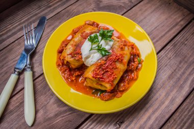 Akşam yemeği domates soslu lahana rulo ile dekore edilmiş maydanoz. Ahşap rustik arka plan. Üstten Görünüm. Yakın çekim