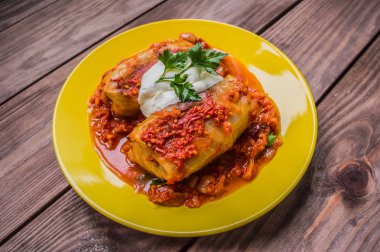 Akşam yemeği domates soslu lahana rulo ile dekore edilmiş maydanoz. Ahşap rustik arka plan. Üstten Görünüm. Yakın çekim