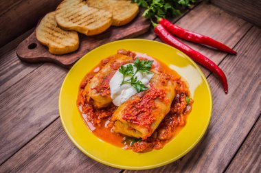 Akşam yemeği domates soslu lahana rulo ile dekore edilmiş maydanoz. Ahşap rustik arka plan. Üstten Görünüm. Yakın çekim