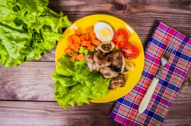 Kızarmış tavuk karaciğer ve akşam yemeği için bıldırcın yumurtası. Kahverengi ahşap zemin üzerinde. Üstten Görünüm. Yakın çekim