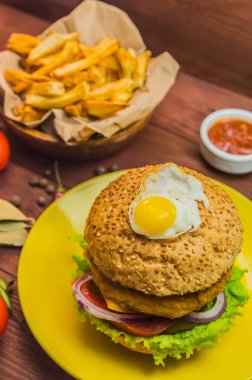 Büyük sandviç - hamburger hamburger tavuk, peynir, domates. Ahşap rustik arka plan üzerinde. Yakın çekim