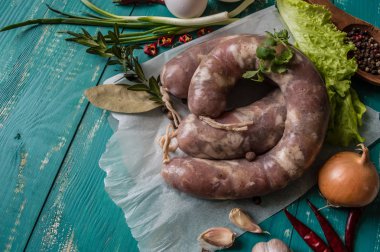 Ahşap turkuaz zemin üzerine baharat ile çiğ sosis. Üstten Görünüm. Yakın çekim