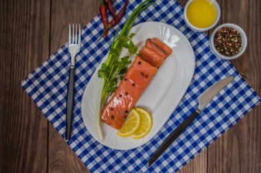 Somon steak, tereyağı, biber, limon ve Yeşiller plaka ahşap rustik arka plan üzerinde. yakın çekim.