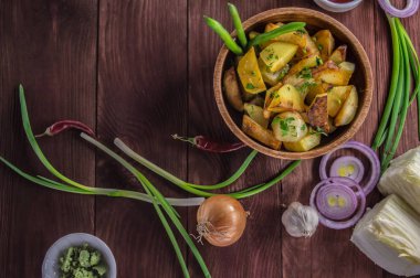 Kavrulmuş patates sebze ve otlar ahşap arka plan, üstten görünüm üzerinde. Yakın çekim