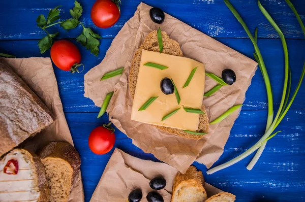 Schnittkäse mit Oliven, Radieschen und Kräutern. auf einem hölzernen Hintergrund. Ansicht von oben. Nahaufnahme — Stockfoto