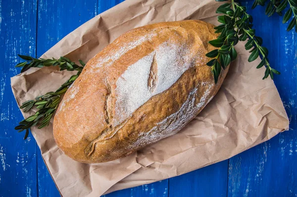 Νωπά ψημένα σπιτικό ψωμί στο ΤΡΑΠΕΖΙ ΞΥΛΙΝΟ μπλε. Το Top view. Γκρο πλαν — Φωτογραφία Αρχείου