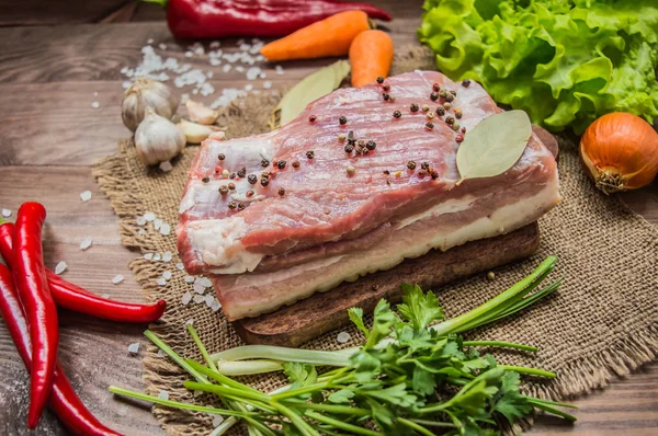 Ruwe spek met kruiden op een houten tafel. Bovenaanzicht. Close-up — Stockfoto