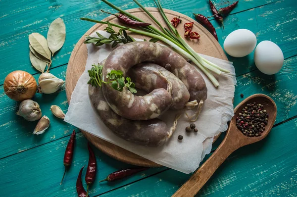 与木青绿色背景上的香料的原料香肠。顶视图。特写 — 图库照片