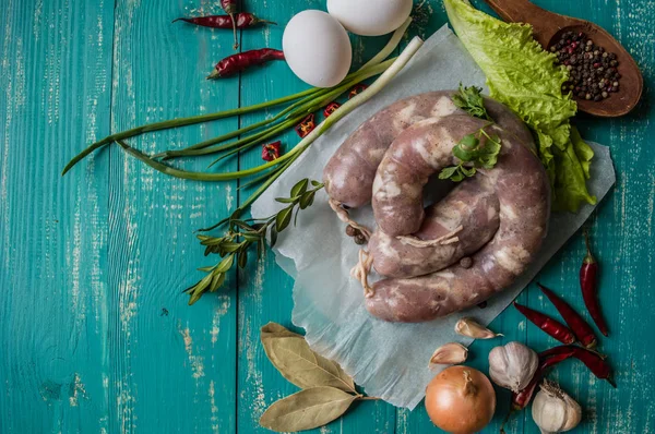 Saucisse crue aux épices sur fond de bois turquoise. Vue de dessus. Gros plan — Photo